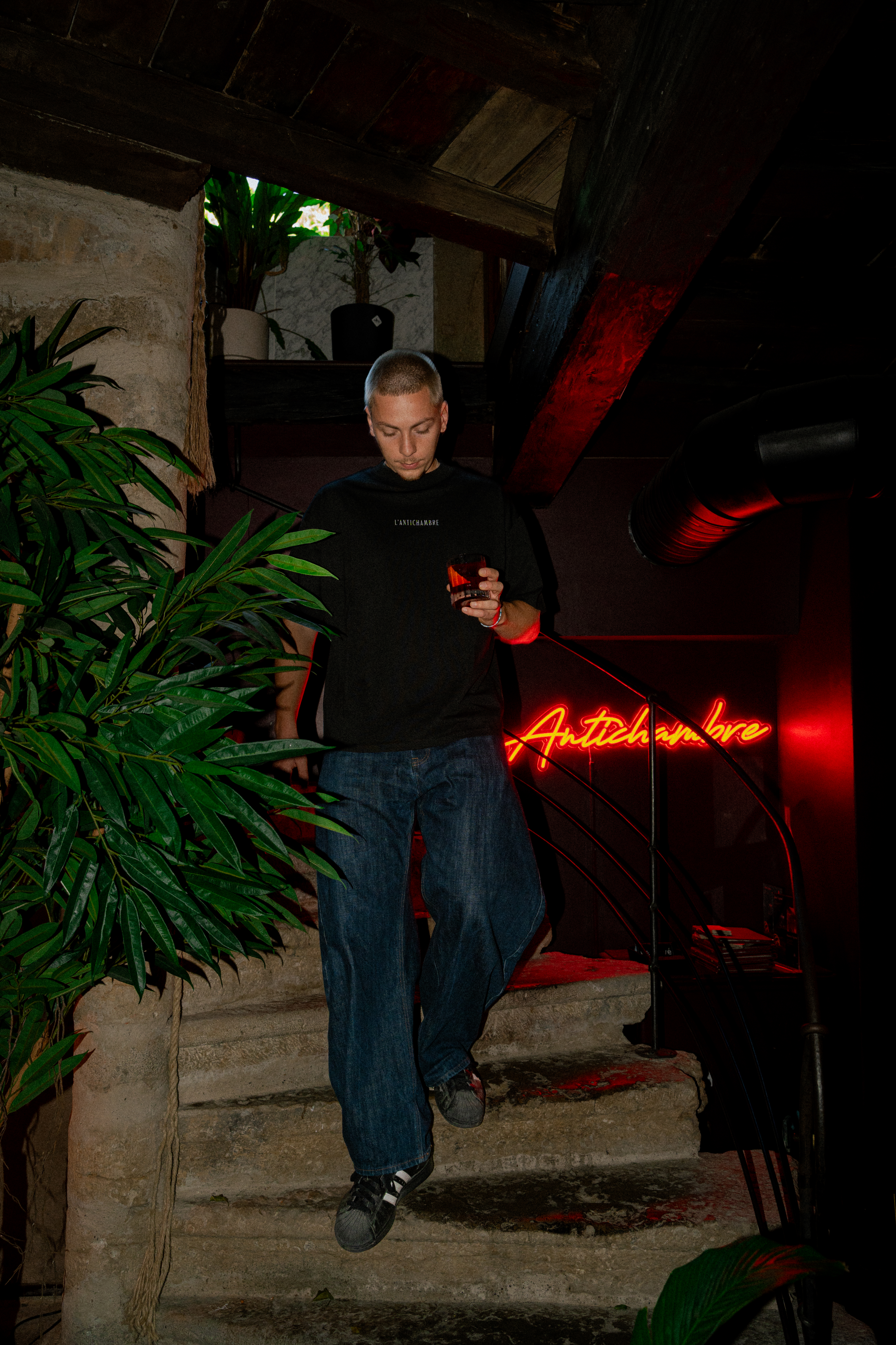 Client sous l'enseigne néon au bar L'Antichambre – photo club., agence créative à Strasbourg
